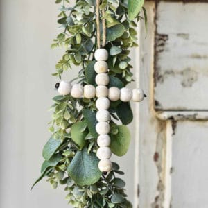 Small white-washed cross made with round wooden beads with twine hanger
